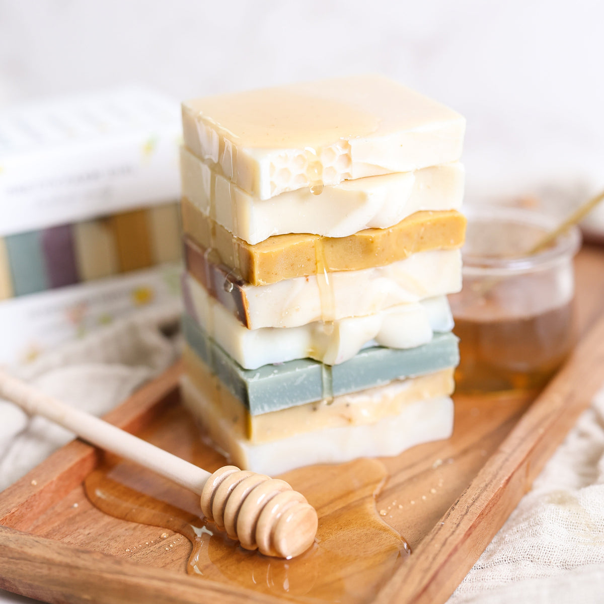 Honeycomb Harvest Goat Milk & Tallow Soap Sampler bars stacked on a wooden board.