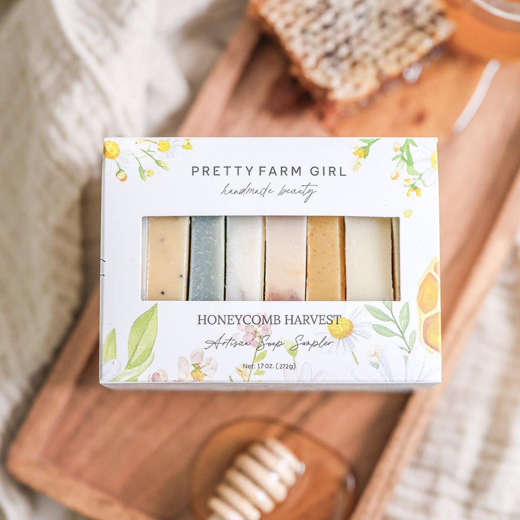 Honeycomb Harvest artisan soap sampler box featuring goat milk and tallow bars on a wooden tray with a honey dipper.